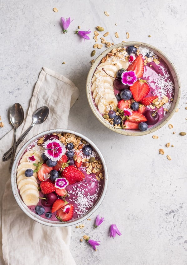 vegan blueberry acai bowls with fruit and seed on top