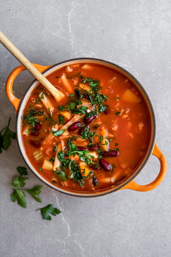 Cozy up with a bowl of this one pot vegan minestrone soup! It takes less than 30 minutes to make and is loaded with hearty good for you ingredients!