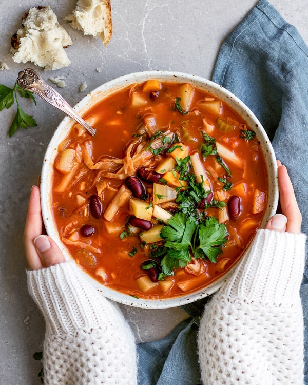 Cozy up with a bowl of this one pot vegan minestrone soup! It takes less than 30 minutes to make and is loaded with hearty good for you ingredients!