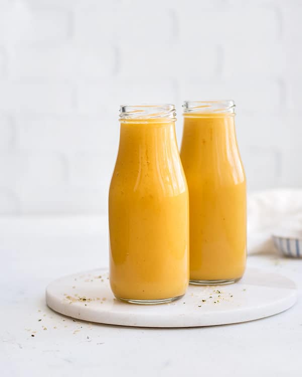 two yellow smoothies in small bottles