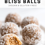 bliss balls rolled in coconut shavings with one half eaten