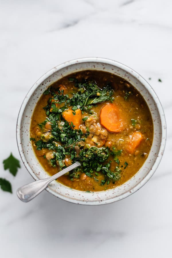 lentil soup topped with parsley in a light blue speckled bowl