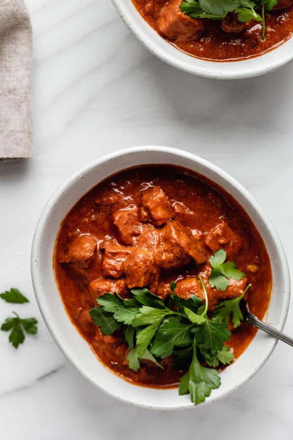 a bowl of tofu tikka masala with a spoon in it