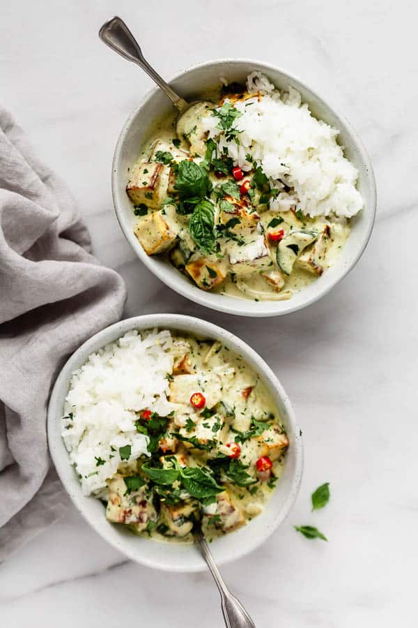 Thai green curry tofu in a bowl with basil, jasmine rice and chilli peppers