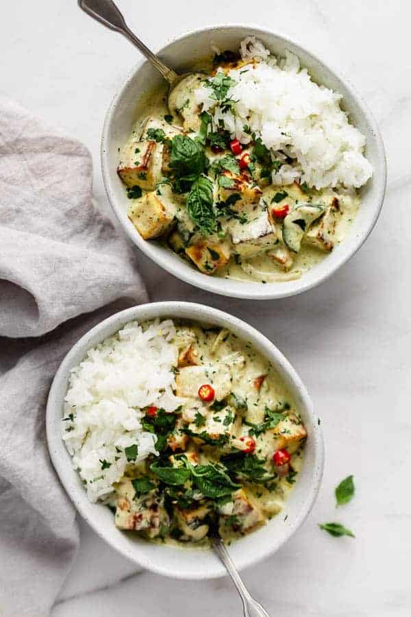 Thai green curry tofu in a bowl with basil, jasmine rice and chilli peppers