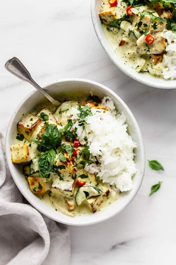 Thai green curry tofu in a bowl with basil, jasmine rice and chilli peppers