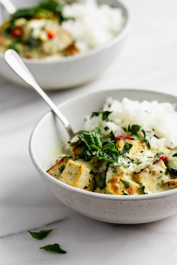 Thai green curry tofu in a bowl with basil, jasmine rice and chilli peppers