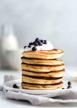 almond flour pancakes on a white plate topped with blueberries