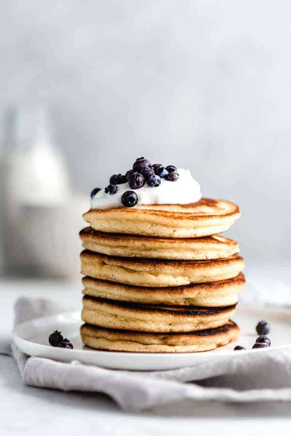 almond flour pancakes topped with blueberries, yogurt and maple syrup
