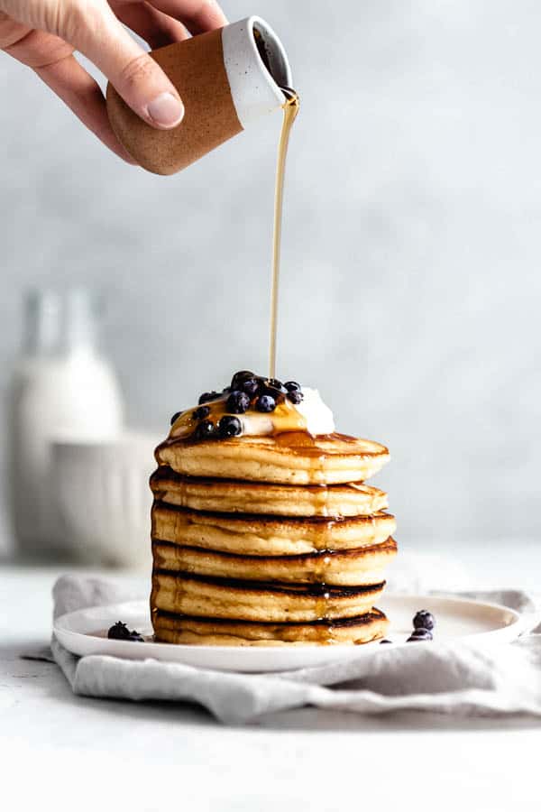 a stack of almond flour pancakes with a drizzle of maple syrup
