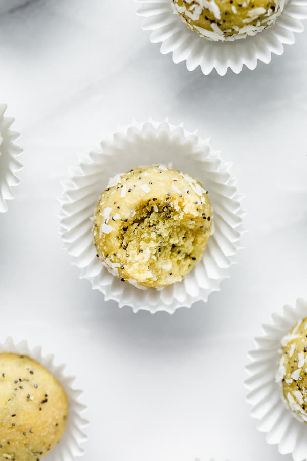 Lemon poppyseed bliss ball with a bite taken out of it