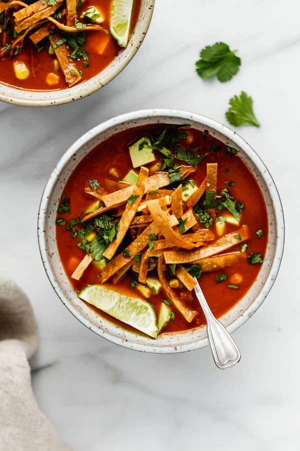 a tortilla soup topped with tortilla strips and fresh cilantro