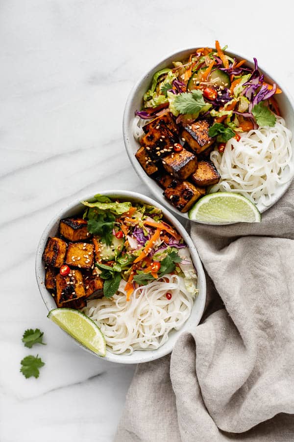 two bowls filled with Vietnamese salad, rice noodles and lemongrass tofu
