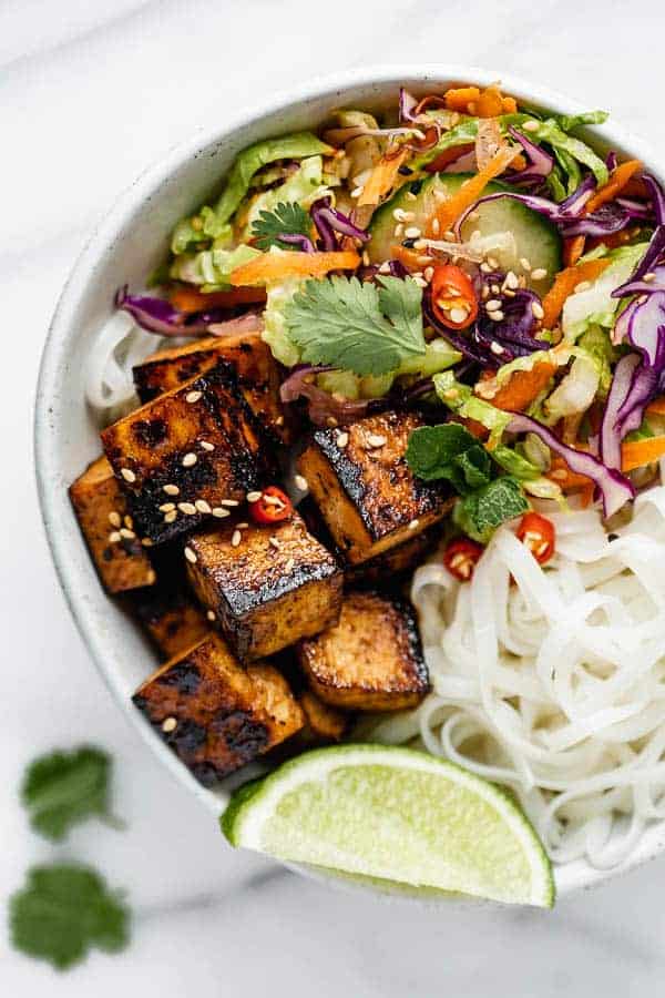 a bowl filled with Vietnamese salad, rice noodles and lemongrass tofu