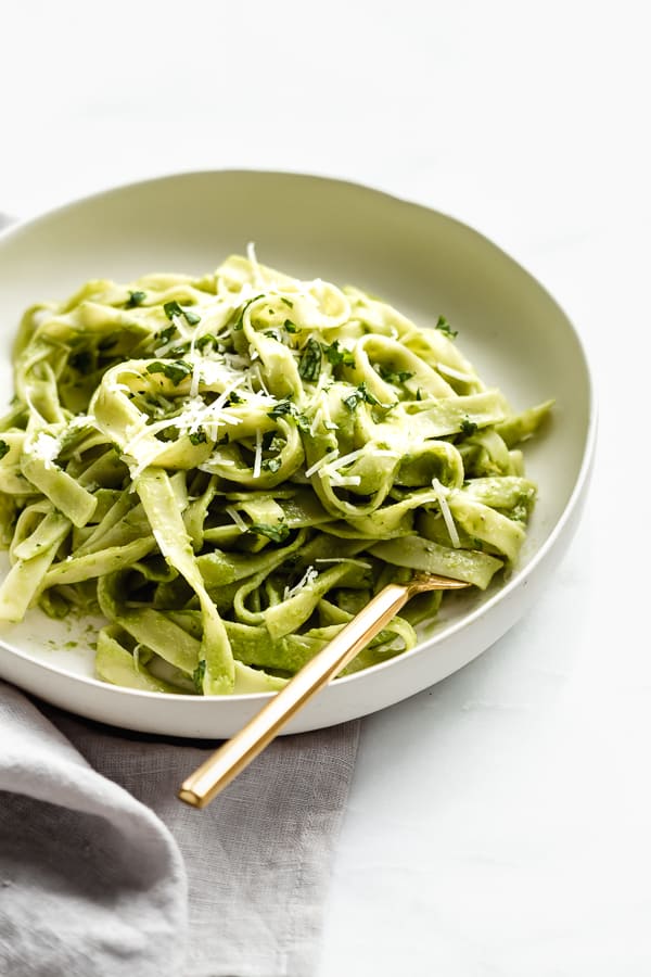 avocado pasta in a bowl with a gold fork