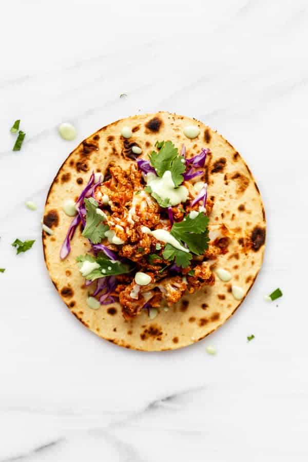 a cauliflower tinga taco on a marble board 