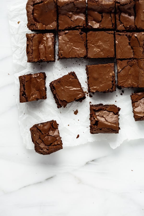 cut up chocolate brownies on a marble pastry board 