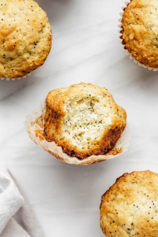 a lemon poppy seed muffin with a bite taken out of it 
