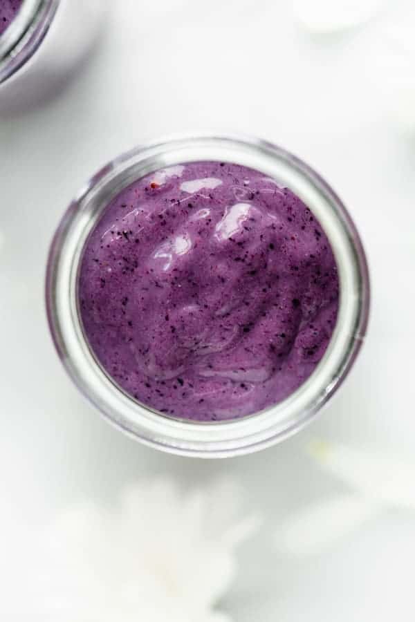 a top down image of a blueberry smoothie in a jar 