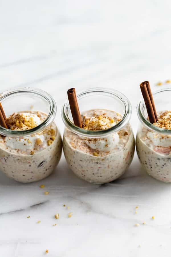 3 small jars with carrot cake overnight oats and cinnamon sticks