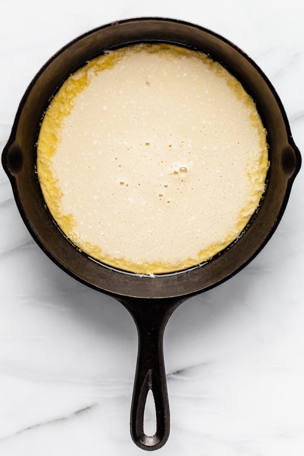 dutch baby pancake batter in a cast iron skillet