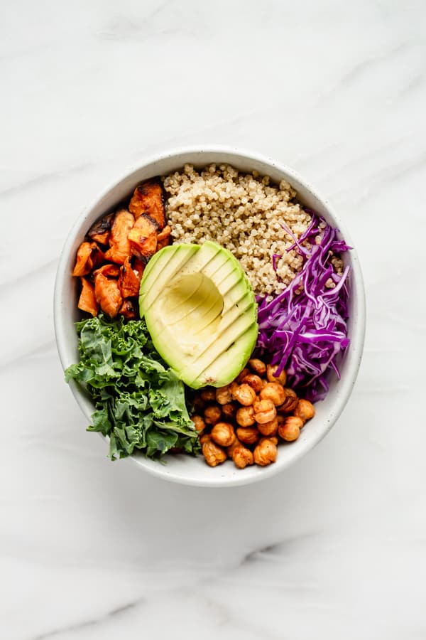 quinoa, cabbage, chickpeas, kale, sweet potato and avocado in a bowl 