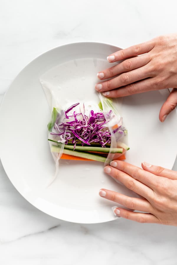 two hands making a vietnamese summer roll