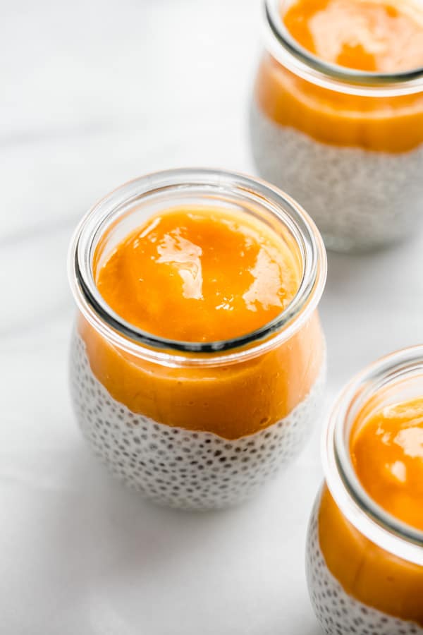 a jar of chia pudding topped with pureed mango