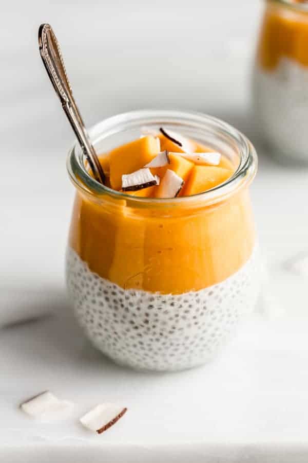 a jar with coconut chia pudding topped with mango puree