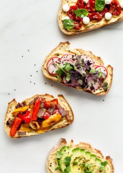 4 pieces of hummus on toast with toppings