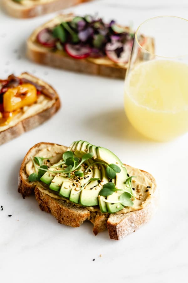 a piece of toast with avocado on a marble board