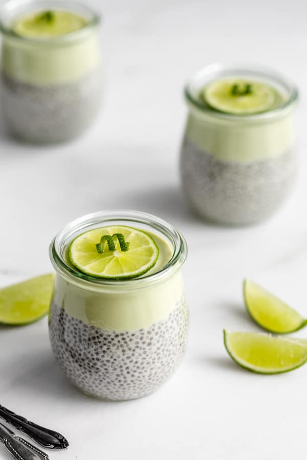 3 jars of key lime chia pudding with a sliced lime on top