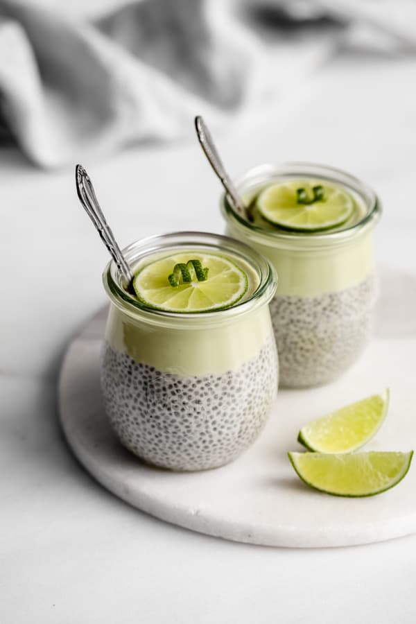 2 jars with key lime chia pudding in them and 2 spoons