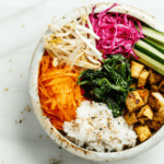 A bibimbap with tofu in a white bowl