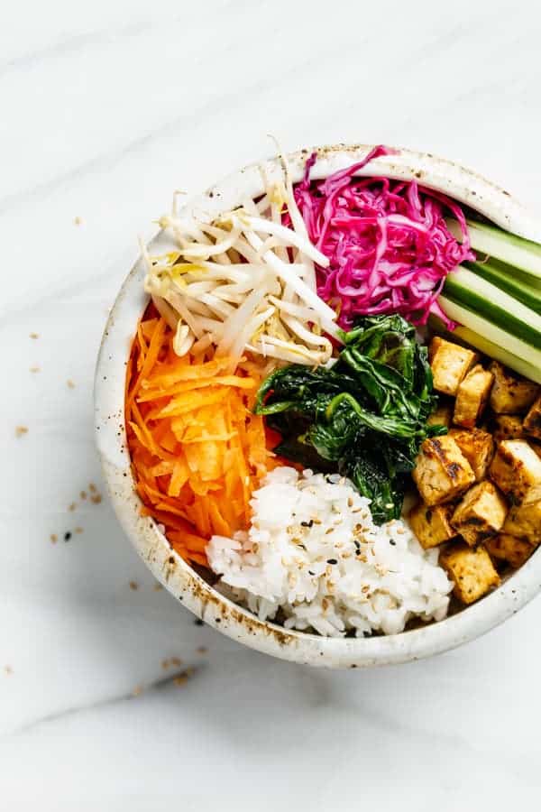 a bowl with carrots, rice, tofu and vegetables