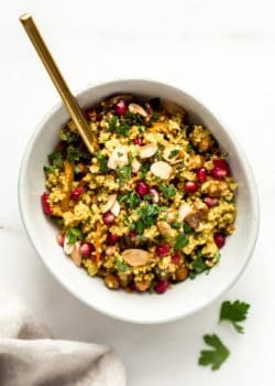 A bowl with Moroccan quinoa salad and a gold spoon