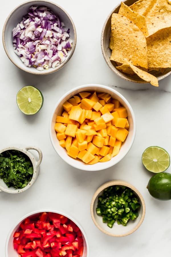 ingredients to make mango salsa chopped up into bowls