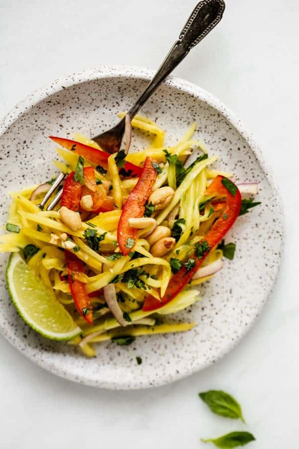 a white plat with mango salad on it