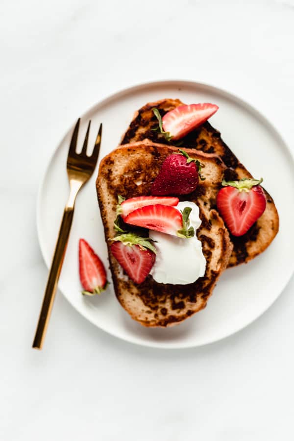 a plate of vegan french toast topped with strawberries