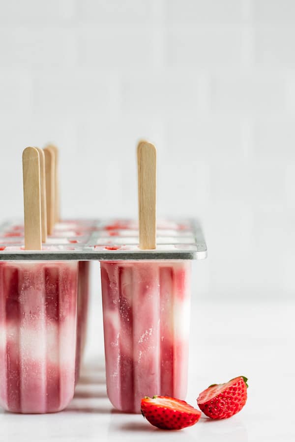 vegan strawberry cheesecake popsicles in a popsicle mold