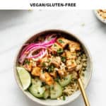 a quinoa and tofu bowl with a gold fork in it
