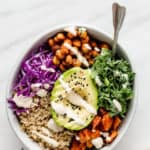 a buddha bowl with vegetables and avocado