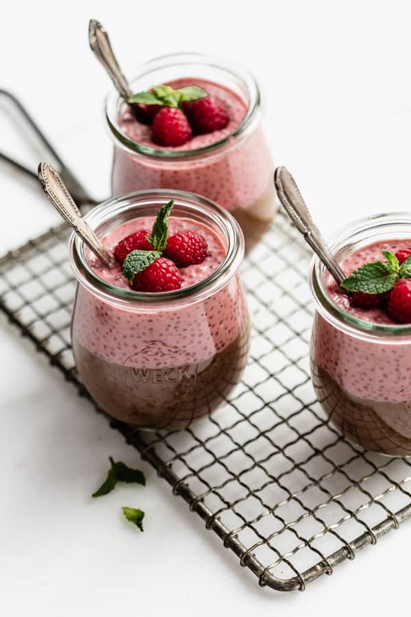 three jars of chocolate raspberry chia pudding on a wire cooling rack