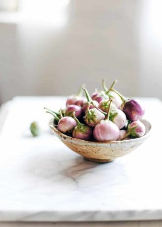 a bowl of mini eggplants