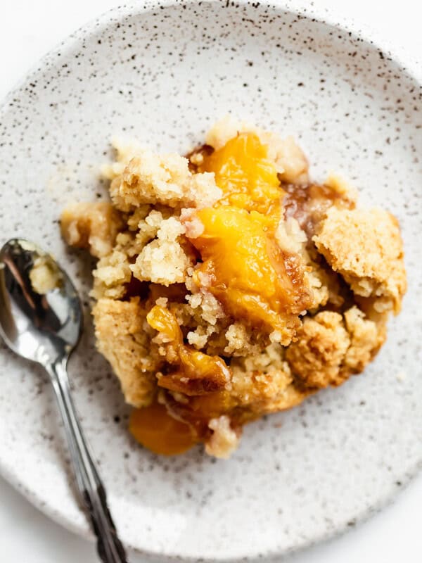 gluten-free peach cobbler on a white speckled plate