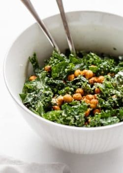 a serving bowl of kale Caesar salad topped with crispy chickpeas