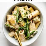 a bowl of rigatoni pasta with asparagus and lemon zest on top
