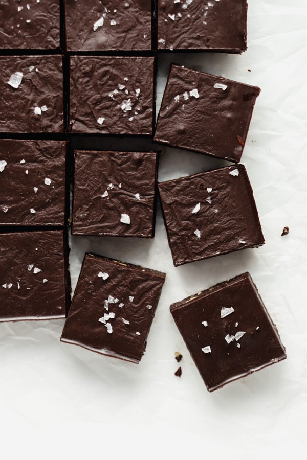 a top down image of no bake brownies cut into squares on a piece of parchment paper