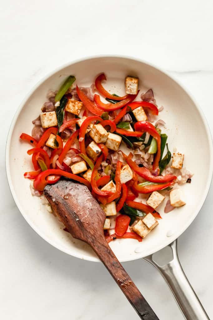 tofu red peppers and onions in a white pan
