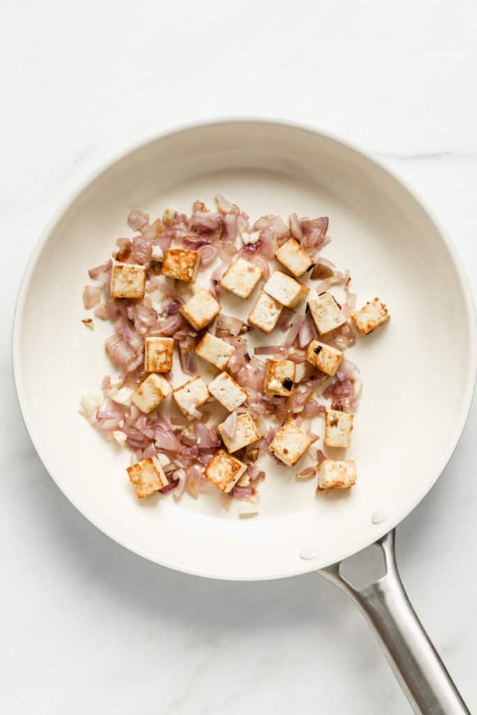 shallots and tofu in a white pan